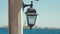 Vintage decorated night lantern on the sandy sea beach with the palm leave. Outdoor lamp on at the ocean sunset. Copy