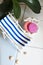 A vintage decorations striped lounge for relaxing is standing near swimming pool or bath, seashells, soap, solid shampoo, soap