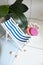 A vintage decorations striped lounge for relaxing is standing near swimming pool or bath, seashells, soap, solid shampoo, soap