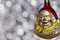 Vintage decorative christmas bauble in a shape of a crown jester against a silver bokeh blury star background