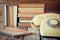 Vintage dial phone, phone book next to stack of old books over wooden table. vintage filtered image