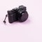 Vintage digital compact camera on pink pastel color