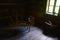 Vintage dimly lit wooden cottage room with brace wheel and basket, as displayed in museum of Orava village in Vychylovka