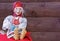 Vintage doll - a gray-haired grandmother in a national Russian dress and bast shoes on a brown wooden background