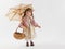 Vintage doll in pastel colored clothing with parasol and basket