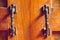 The vintage door handle on an old wooden door background and lighting and shadow in the morning.