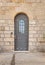 Vintage door with metal belts and rivets and barred window, Stella Maris Monastery in Haifa