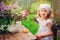 Vintage dressed child girl decorating cakes with flowers on garden tea party in spring