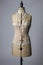 Vintage dressmakers dummy wearing a corset and with pearl necklaces around its neck