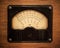 Vintage electric multimeter on wooden panel