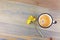 Vintage enamel coffee cup and daisy flowers on wooden table.