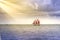 Vintage and exotic sailboat sailing in South Florida toward the sun rays