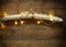 Vintage fabric hanger with gold Christmas warm gold garland lights on wooden rustic background. filtered image