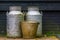 Vintage farm equipment, metal milk cans and a old rusty bucket, agriculture background