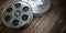 Vintage film reel with filmstrip on wood background. Video, cinema, multimedia concept