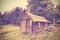 Vintage filtered wooden hut in forest.