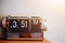 Vintage flip alarm clock on wooden table with light