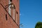 A vintage gas powered lamppost hanging on a red brick wall