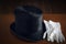 Vintage gentleman`s top hat with a pair of white gloves