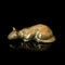 Vintage gold figurine of a cat on a black isolated background