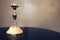 Vintage golden bronze candlestick with melted candles on a wooden table on the background of a concrete wall