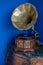 Vintage gramophone. Old record players take on the blue background. Golden gramophone with disk on wooden box isolated on blue bac