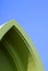 Vintage green gable roof in curved triangle shape against blue sky background