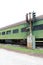 Vintage green railway passenger car with partially boarded windows and old railway track light