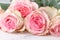 Vintage group of pink roses on wooden table, soft focus