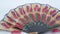 Vintage hand folding fan made of paper. Brown stick made of wood. Hand painted and decorated hand folding