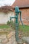 A vintage hand operated green stand water pump.