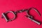 Vintage handcuffs on a scarlet background.