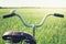 Vintage handlebar with bell on bicycle. Summer day for trip. View of wheat field. Outdoor. Closeup.