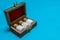 Vintage homeopathic bottles of pills in classic wooden old box on blue background