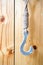 Vintage hook hanging on wooden panel wall