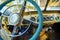 Vintage interior of an old car with a retro dashboard and steering wheel in a PVC cover