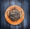 Vintage iron stand in form of a tea pot on circle board and blue wooden background, tea concept