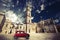 Vintage Italian scene, an old church with a bell tower and old small red car