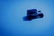 Vintage jeep toy car with a shadow on a table under blue light