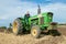 Vintage John Deere tractor pulling a plough