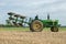 Vintage John Deere tractor pulling a plough