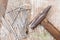 Vintage joiner hammer and nails hobnails lying on old wooden table or workbench with splashes paint on it. Tool master carpenter