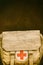 Vintage jute first aid army bag in front of an old brown weathered background