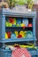 A vintage kitchen blue sideboard filled with colored dishes, plates, cup dishes and miscellaneous kitchen utensils. Beautiful