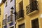 Vintage lantern and beautiful twisted wrought iron balconies on the facade of an old house of a European city