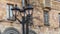 Vintage lantern with empty branches in the city on building background. Beautiful streetlight in front of old building.