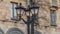 Vintage lantern with empty branches in the city on building background. Beautiful streetlight in front of old building.
