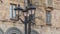 Vintage lantern with empty branches in the city on building background. Beautiful streetlight in front of old building.