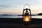 Vintage lantern at sunset, romantic evening at the beach.