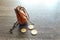 Vintage leather pouch on wooden desk, with euro coins next to it